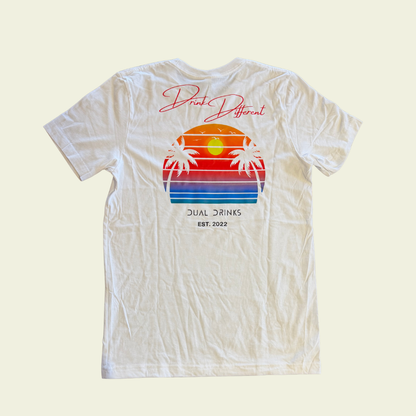 White t-shirt with a colorful beach graphic and text on a light beige background